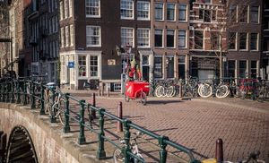 Fietskoeriers halen in Amsterdam producten op bij winkeliers